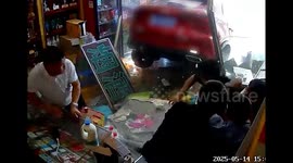 Car reverses out of control and crashes through shop, narrowly missing card players inside