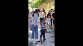 Little girl gently helps shy boy off the street in Henan, China