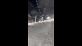 Wind creates eerie conditions as powder blows across ski slope