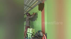 Father wears motorcycle helmet to do DIY next to bee hive