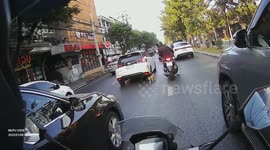 Motorcycle rider saves stray tabby cat wandering across busy road