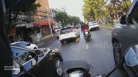 Motorcycle rider saves stray tabby cat wandering across busy road