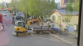 Excavator skillfully climbs onto truck in Beijing, China