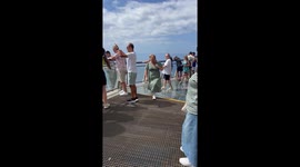 Woman tries to keep her dress down while cruising with family