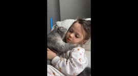 Girl hugs and kisses cat in sweet moment with baby in İstanbul