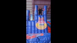 Aunt and child fall onto side trampoline during playful moment in Saylla, Cusco, Peru
