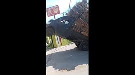 Pickup truck overloaded with cardboard topples over backwards