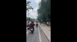 Motorist drives with chair on head while carrying baby