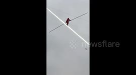 Daredevil acrobat appears to walk on light in dazzling stunt 80m above ground in China