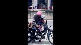 Motorcycle rider tends to canine companion joining him at work
