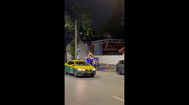 Backpackers ride on tuktuk roof in Bangkok