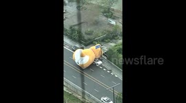 Chaos as giant inflatable dog blown into traffic by strong winds in China