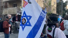 Demonstrants yells slogans, sits or stands holding signs and waving Israeli or yellow flag in front of Benjamin Netanyahu private house