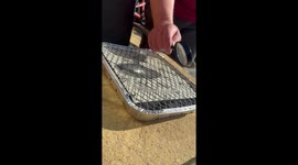 Dad starts BBQ with magnifying glass and sunlight in Motherwell, Scotland, UK