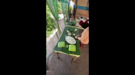 Locals prepare food spread on banana leaf for guests