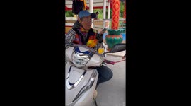 Motorcycle taxi rider carries pet birds on her handlebars