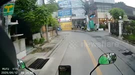 Motorcycle collides with car during turn in Bangkok, Thailand