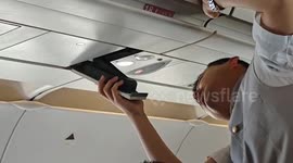 Cabin crew try to fix reading light that failed mid-air in China