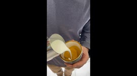 Coffee roasting business owner masterfully pours latte art into his coffee