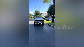 Custom car drives with elevated stance downtown