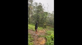 Two men slip on muddy trail during hike in East Java, Indonesia