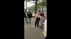 Man uses giant fish to bounce stray ball away in Hubei, China