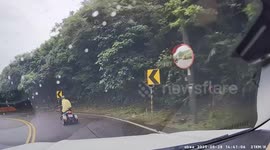 Man riding modified three-wheel motorcycle topples off the side of road