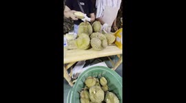 Watch fresh durian prepared on market stall in Thailand