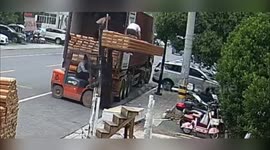 Forklift truck bumps along pavement sending worker toppling to ground
