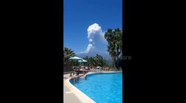 Tourists watch on from hotel pool as Mount Etna erupts in background