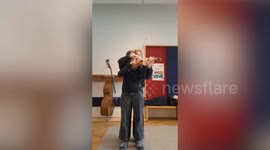 Violin students learn to play a single violin at the same time