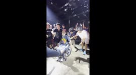 Rock fans lift up wheelchair user to give him a clear view of the concert