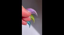 Close up shots of a set of hand sculpted nails that are shaped like big hooked claws. They are see through and glittery.