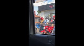 Motorcycling Man Drinks From Beverage Dispenser
