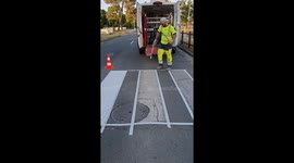 Skilled worker sprays zebra crossing onto road with great precision