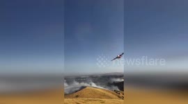 Plane dumps retardant on grass fire in Fairfield, California
