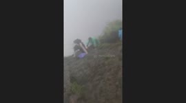 Hikers battle through intense winds on hillside in the Philippines