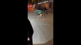 Three boys carry broken-down scooter on the back of motorcycle