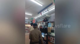 Tourist baffles supermarket staff by climbing onto shelves