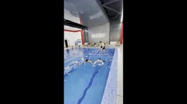 Hilarious moment friends form a swimmer's chariot