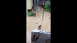 Man swims in neck-deep flood during heavy rain in Zamboanga City, Philippines