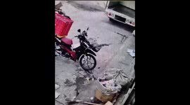 Motorcycle overturns but parcel breaks the fall in Bangkok, Thailand