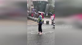 China: Barefoot Police Officer Directs Traffic In Heavy Rain To Protect Students After Exam