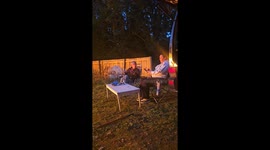 Woman lost in her phone lets out a scream after campfire prank surprises her