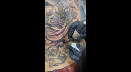 Schoolboy retouches tattoo patterns on father's back with real machine