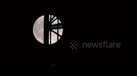 The June Full Moon known as the Strawberry Moon rises from the viewpoint of Waterloo Bridge