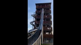 Girl tumbles side-to-side down a huge slide