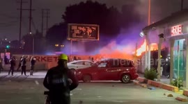 Police cars set alight during protests in LA