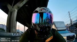 Newspaper flies into motorcycle rider's face on road in Bangkok