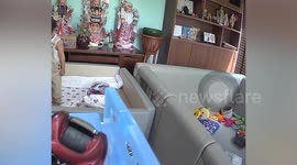 Alert father saves son from falling over playpen by pulling his foot
